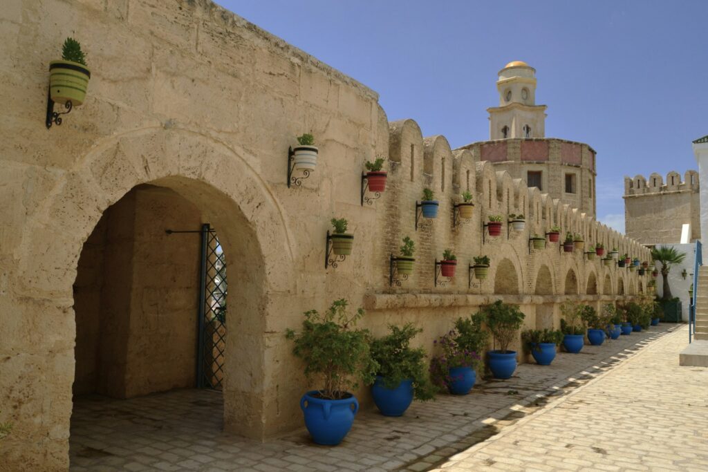 Alte mura di cinta in pietra della Kasbah di Hammamet che proteggono la Medina, affacciate direttamente sulle acque turchesi del Mediterraneo