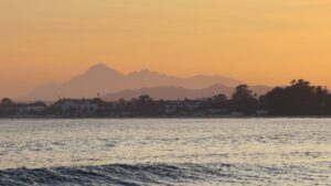 Profilo costiero di Hammamet visto dall'acqua: le caratteristiche case bianche della città vecchia protette dai bastioni della Kasbah lungo il Mediterraneo.
